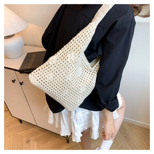 Close-up of cream crochet bucket bag with hollow mesh pattern and fabric liner