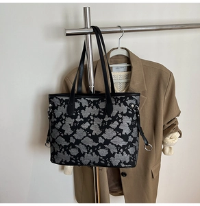 Dettaglio borsa tote grigia trama astratta con manici in pelle e anello metallico