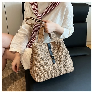 Détail du sac cabas en paille tressée avec sangle en cuir noir et boucle en métal doré