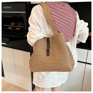Détail d'un sac cabas en paille tissé main avec boucle en cuir noir en décor intérieur