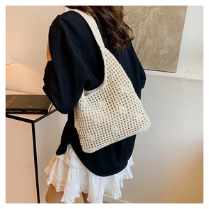 Detailed texture of off-white hollow crochet bucket bag with boho woven patterns