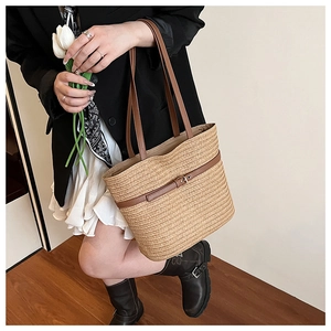 Detail showing natural woven straw texture with brown leather strap and metal buckle