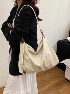 Minimalist cream white oversized tote bag with brown leather trim shown on model