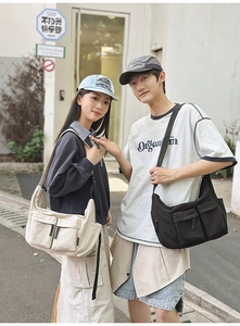 Detail of cargo crossbody bags in black and beige with dual front pockets and adjustable straps