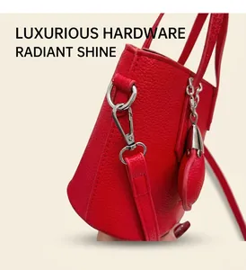 Detail of red lychee grain leather bucket bag with silver hardware and heart charm