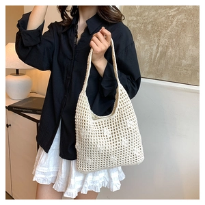 Close-up of cream crochet bucket bag showing detailed hollow knit and floral pattern