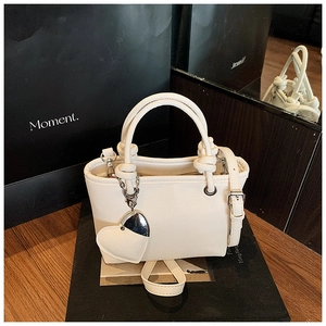 Detailed macro of white litchi pattern bucket bag with heart charm and round handle