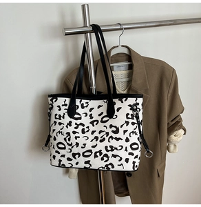 Dettaglio della borsa tote leopardata con fibbia in metallo argento e cinturini neri