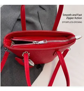 Detailed top view of red lychee grain leather bucket bag showing zipper and heart charm