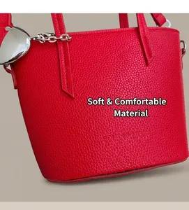 Close-up of red lychee pattern leather bucket bag with heart-shaped metal charm detail