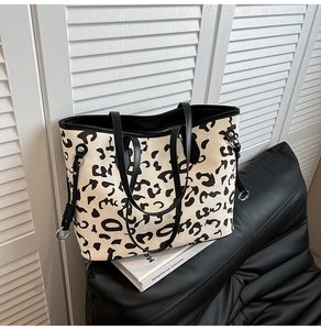 Dettaglio borsa shopper animalier con spalline in pelle nera e anelli metallici