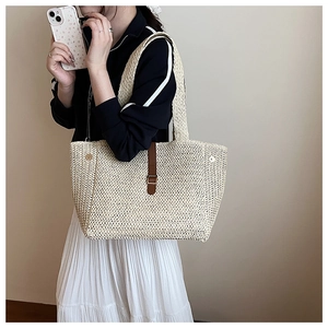 Détail d'un sac cabas en paille tissé main avec boucle en cuir et large poignée