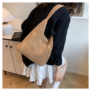 Detail of hand-woven hollow bucket bag in natural straw with square mesh pattern