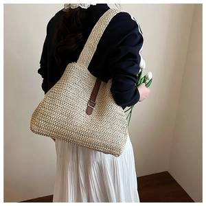 Sac fourre-tout en paille avec lanières en cuir marron porté pour un style de vacances