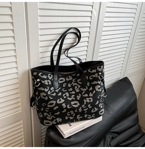 Dettaglio di una borsa tote grande con stampa leopardata grigia e dettagli in argento