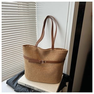 Macro detail of the woven texture and brown faux leather buckle on a beach tote bag