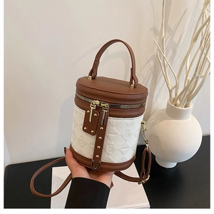Detail of two-tone bucket bag featuring brown lychee grain and white embossed textures