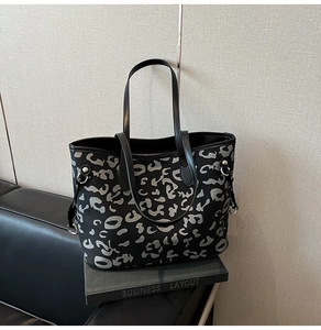 Dettaglio della trama leopardata argento e fibbia metallica sulla borsa tote