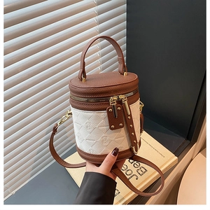 Detail of color-block bucket bag with litchi grain leather and gold hardware