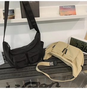 Close-up of durable canvas messenger bags featuring dual front pockets and buckle straps