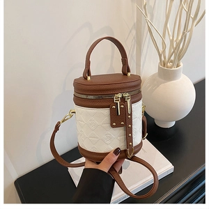 Detail of two-tone bucket bag with bear patterns, leather texture, and gold hardware