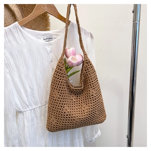 Detail of brown hollow straw bucket bag with hand-woven mesh texture and shoulder strap
