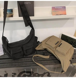 Detail view of khaki and black messenger bags with functional front cargo pockets