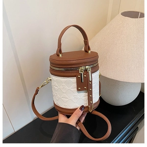 Detail of a brown lychee grain leather bucket bag with white diamond patterned finish