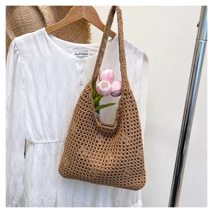 Detailed close-up of brown crochet woven shoulder bag with hollow mesh design and soft texture