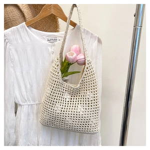 Detail showing hand-woven hollow bucket bag with pink tulips for vacation style
