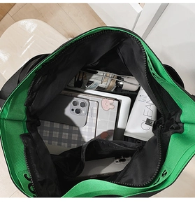 Vue intérieure du grand sac cabas noir avec doublure verte montrant le volume de rangement