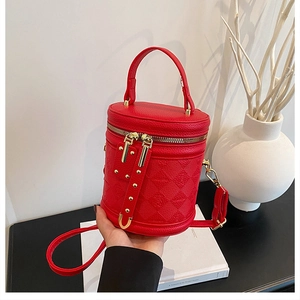 Detail of red leather vanity bucket bag with embossed monogram and gold hardware