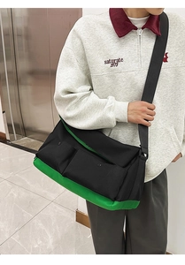 Détail d'un grand sac bandoulière en toile avec blocs de couleurs noir et vert et poches