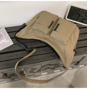 Detail of khaki nylon crossbody bag with dual utility pockets and adjustable strap
