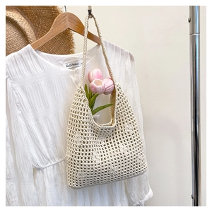Detail of cream crochet knit hobo bag with hollow mesh pattern and long shoulder strap