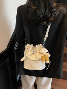 Fashionable beige lychee grain bucket bag with silver chain and cute teddy bear charm