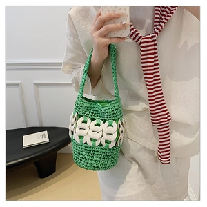 Detail of green handmade crochet bucket bag with decorative white chain link accents