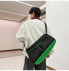 Vue latérale du sac messager noir et vert fluo porté avec une large bandoulière