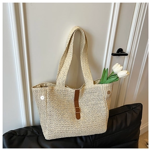 Détail de ce sac cabas tissé beige avec lanière en cuir marron et fermoir magnétique