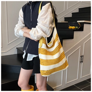 Detail of yellow and white striped knit tote bag with woven texture and leather strap