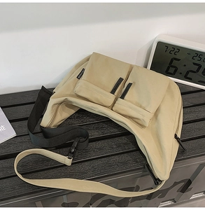 Detail of khaki nylon crescent bag with double front pockets and adjustable strap