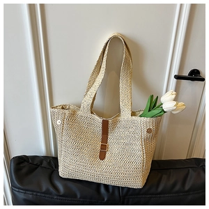 Vue détaillée d'un sac cabas en paille avec lanière en cuir marron et boucle dorée