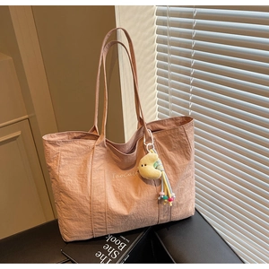 Close-up of pink nylon tote bag texture with TaoCait text and moon plush charm