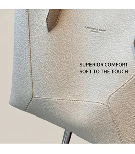Close-up of litchi grain cream leather tote with gold stamped fashion text detail