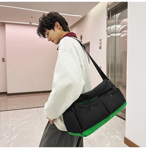 Détail d'un sac de voyage noir et vert avec deux poches avant porté par un mannequin