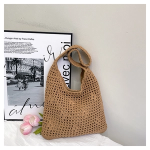 Detailed close-up of khaki crochet shoulder bag with hollow mesh knit and tulip decor