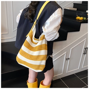 Detail of hollow knit tote bag featuring yellow and white stripes and leather strap