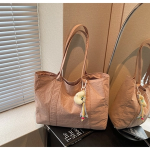 Detail of Morandi pink fabric tote bag with embroidery and yellow moon plush charm