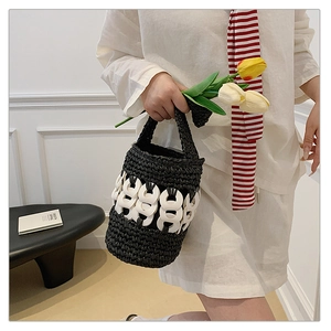 Handwoven straw bucket bag with contrasting black texture and white resin ring detail