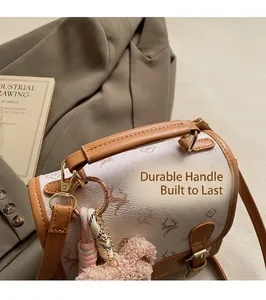 Close-up of retro cream canvas backpack with deer pattern print and pink plush charm